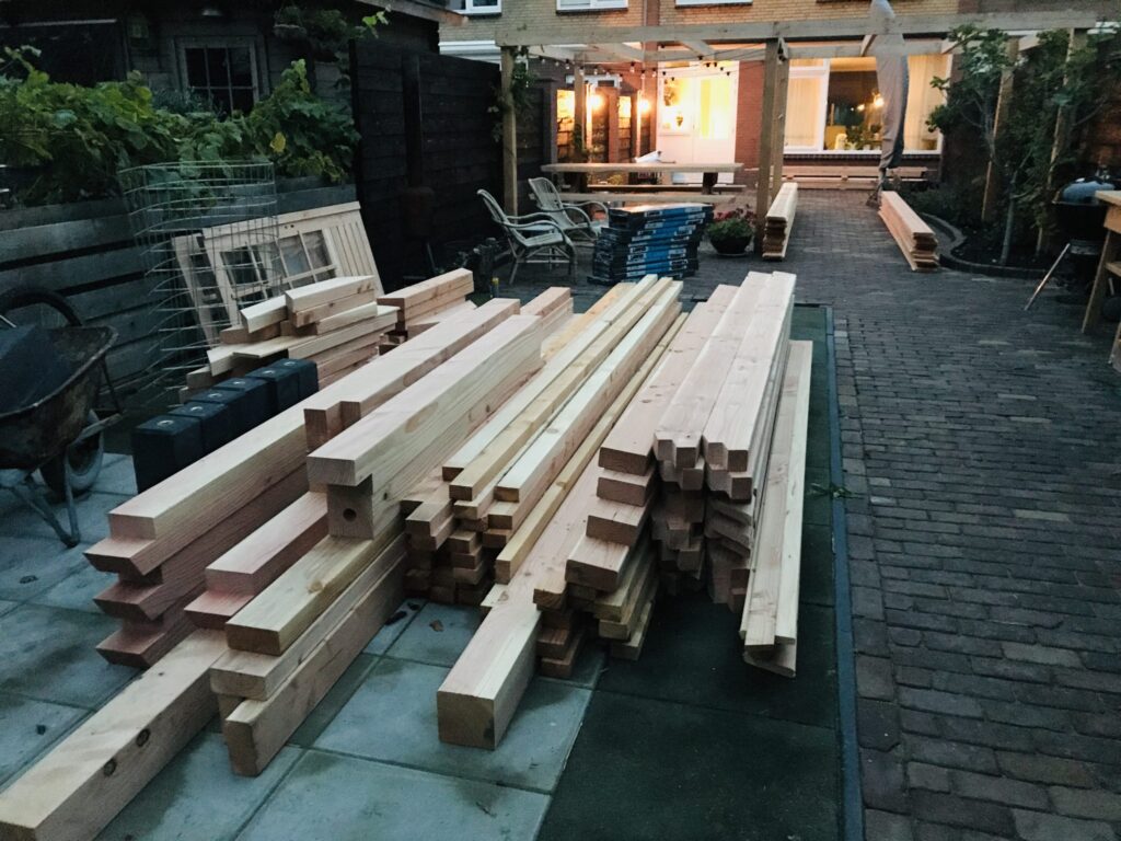een stapel balken, planken en kozijnen.